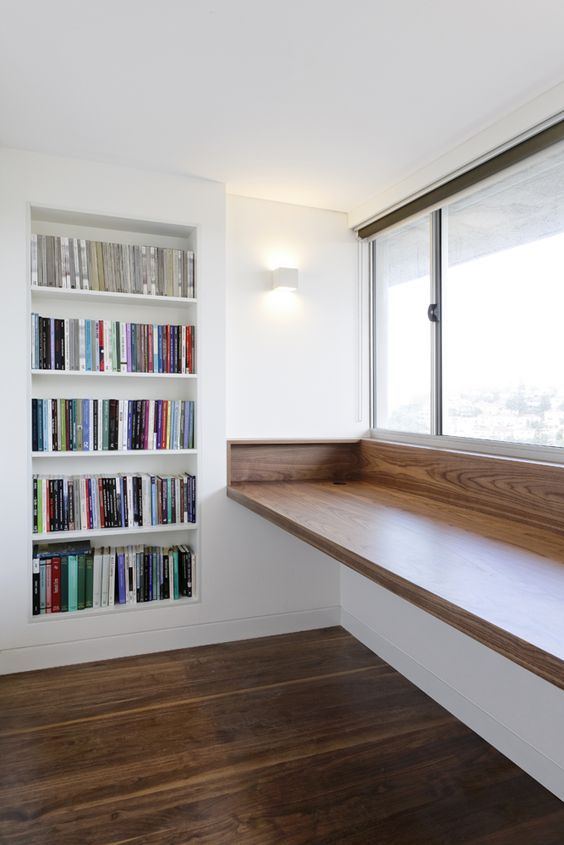 a very comfy study space with a bult-in bookcase and a large windowsill desk