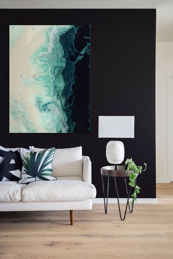 a bold statement artwork on a black wall is a chic idea and black will highlight it