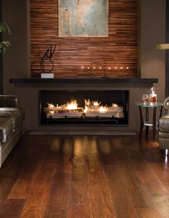 a built-in fireplace with a mantel and an accent wooden wall over it