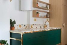 14 an emerald cabinets with brass framing and a terrazzo countertop for a bold and chic look