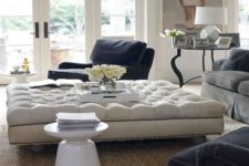 14 an oversized tufted ottoman adds a refined touch to the space and works as a coffee table