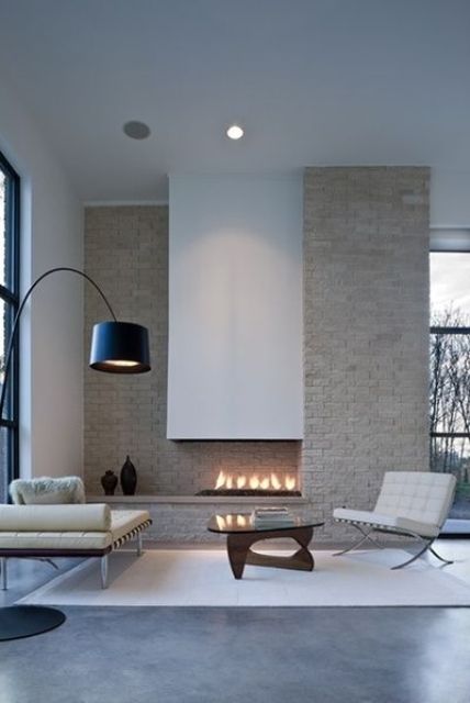 a creamy brick wall and a built-in fireplace with a hood for a cool look