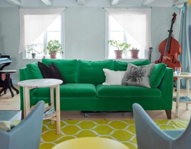 an emerald Stockholm sofa, a yellow rug and powder blue chairs add color to the space and make it bold