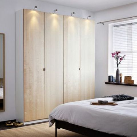 Light colored plywood doors with little handles make the wardrobe cool and chic