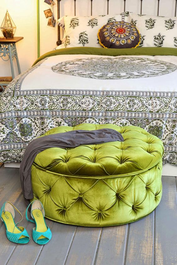 a large green grass upholstered ottoman provides storage and works as a bedroom bench