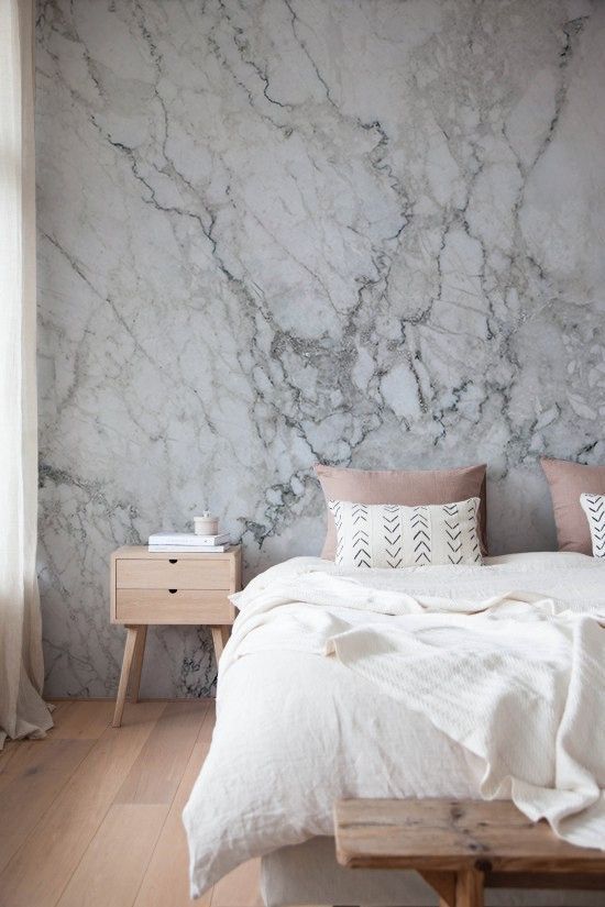 a marble wallpaper headboard wall keeps the space relaxing yet interesting