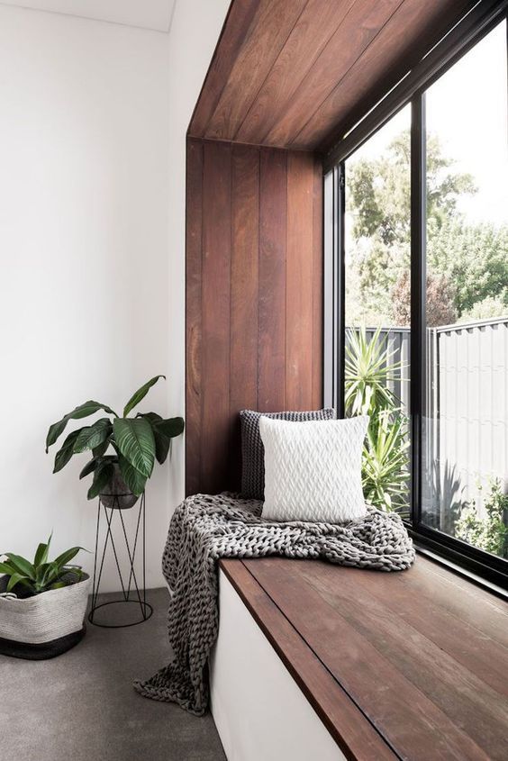 a windowsill covered with dark stained wood is a great seat or daybed