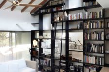 23 the ceiling is acctuated with faux beams and a large and tall bookcase