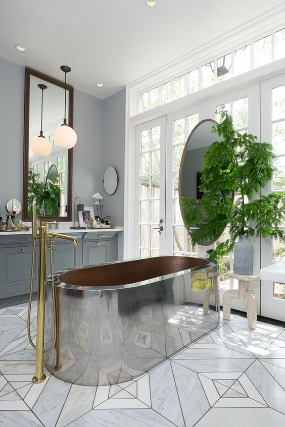 a large metal tub is the main eye-catcher in this bathroom, and brass touches make it cozier