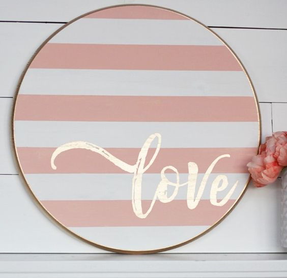 a striped blush and white wooden sign with gold calligraphy