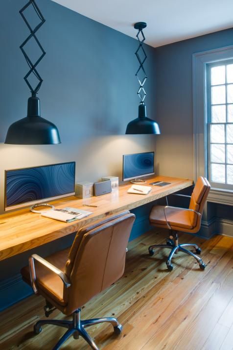 a shared workspace with a floating desk and a couple of leather chairs on casters for comfy working