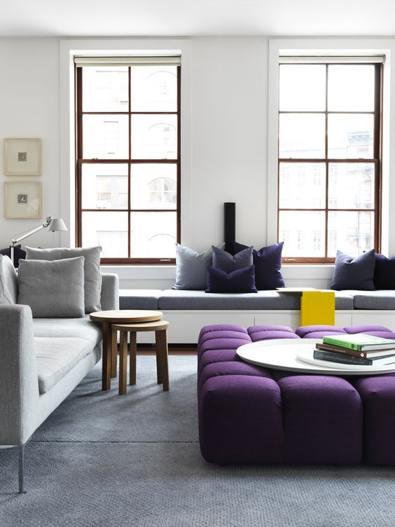 an oversized upholstered purple ottoman spruces up the neutral space and adds a touch of color
