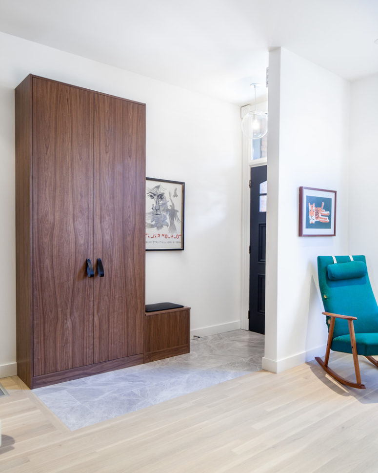 Custom walnut panels and doors and leather pulls turn narrow depth wardrobes into a luxorious storage solution for an entryway. (Wanda Ely Architect Inc.)