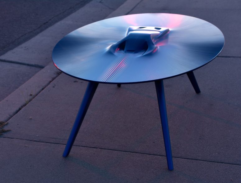 Bold Ford GT table features a vehicle that seems to be appearing from liquid metal in the center of the table