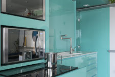 02 Sleek green surfaces make the kitchen stand out and visually separate this utility zone from the rest of the space