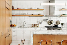 02 The kitchen united with the dining space is filled with light, done with white tiles and cabinets and some marble