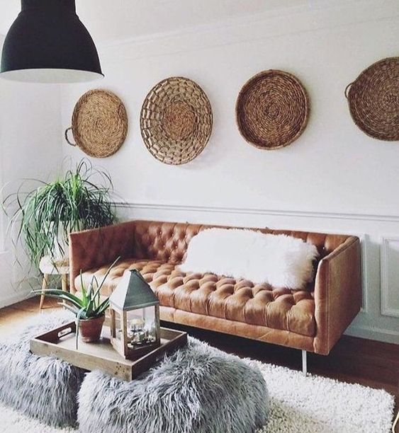 a boho space with an amber leather Chesterfield and baskets on the walls