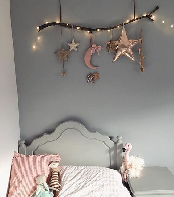 a branch with stars and half moons and string lights for cherring up the sleeping nook