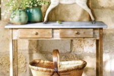 02 a rustic console table with a large basket, a statuette and some potted flowers