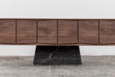 03 The Trinchador credenza features wooden cabinets with a 3D effect and a black marble bse