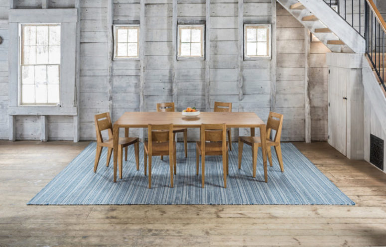 Tula dining table and chairs on the Amma area rug that features blue stripes