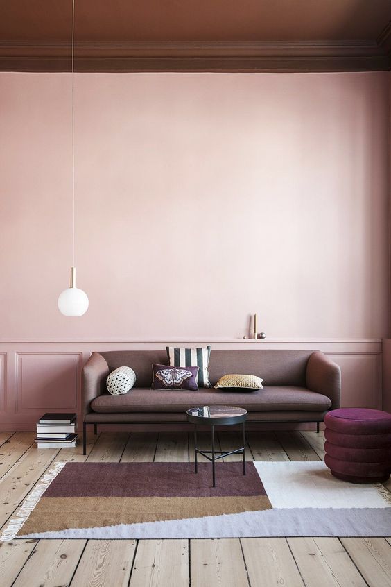 a chic pastel space with a blank pink wall that makes the space balanced