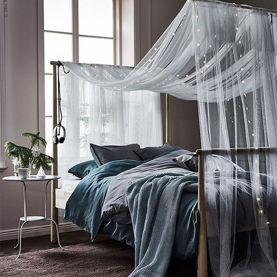 a sheer and airy bed canopy with string lights for comfortable sleeping