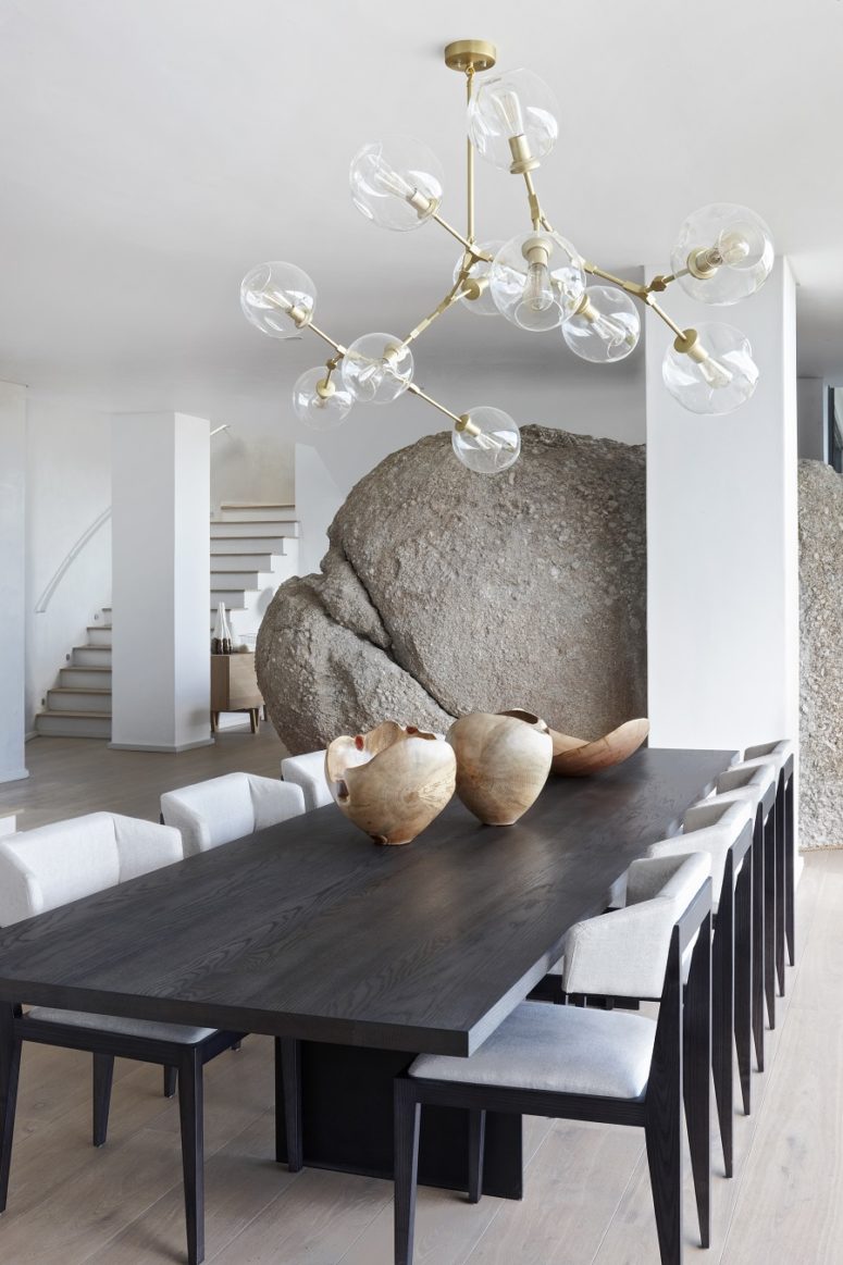 The dining and living spaces are separated with an oversized boulder