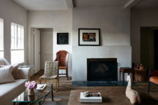 04 The walls are done with white plaster, the floor is of weathered wood, a fireplace adds coziness and baskets too