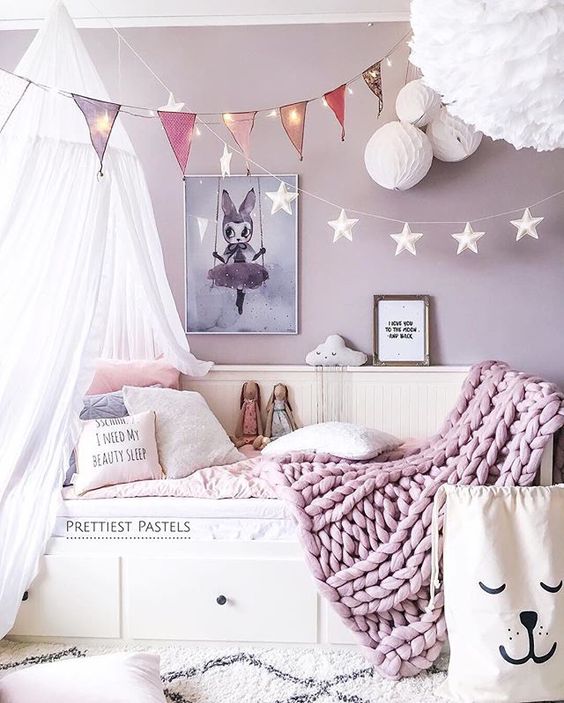 a bunting with string lights over the bed to make the sleeping space cozy