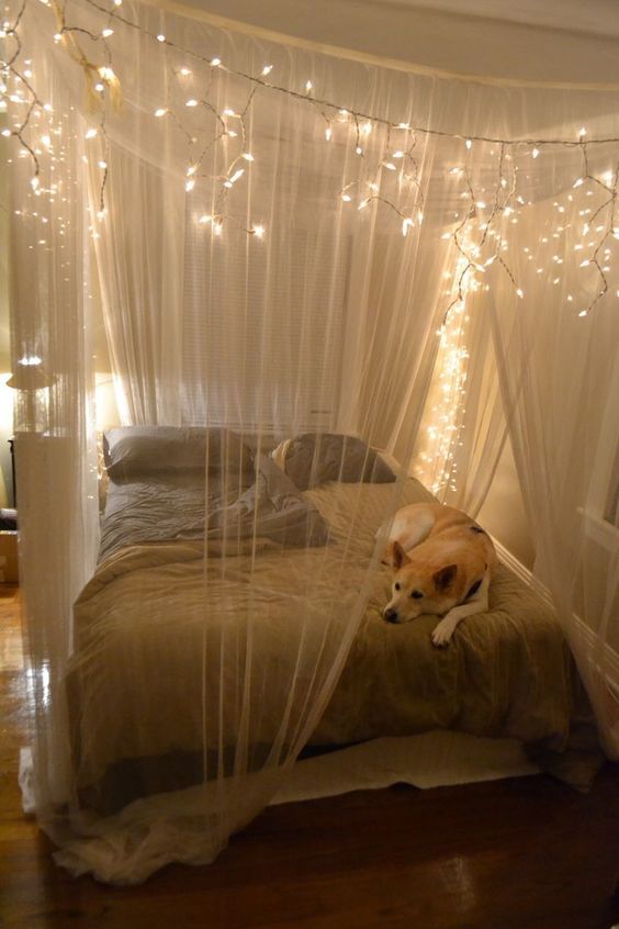 a sheer fabric canopy with string lights to highlight the sleeping space and make it comfier