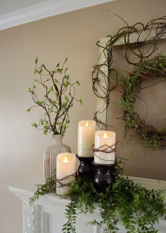 a vine wreath with greenery, pillar candles and cascading greenery plus some in a vase