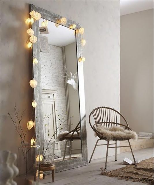 an oversized floor mirror with string lights makes the space cooler and inviting