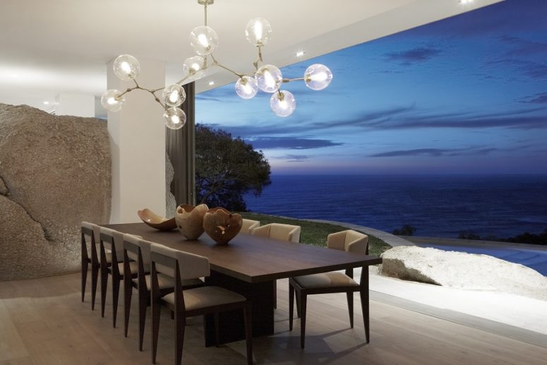 The dining space can be fully opened to outdoors and features a cool bubble chandelier and a chic dining set