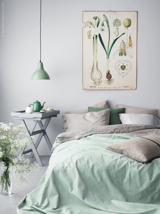 a vintage poster over the bed perfectly fits a grey and mint space