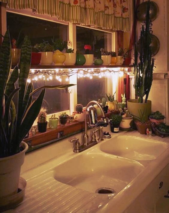 the shelf across the window is lit up with string lights to make the space cozier