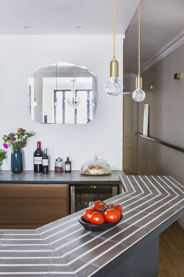 The countertops are striped, and a mirror reflects light and makes the space more glam