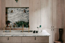 06 The kitchen is clad with untreated wood, there are elegant marble and brass accents