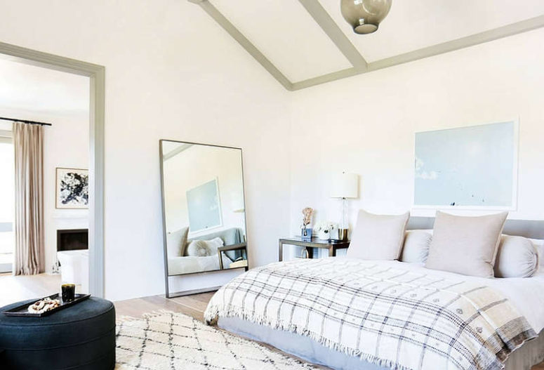 The master bedroom is done in light shades, with an oversized mirror