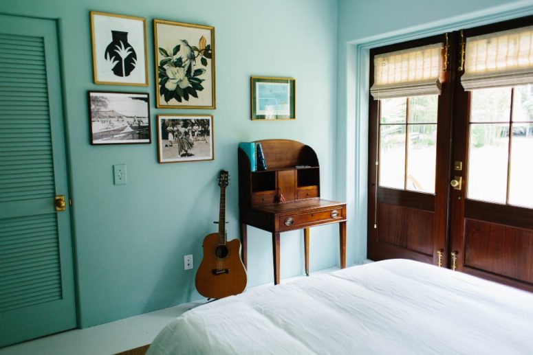 This bedroom is done in turquoise to remind of the ocean, and the artworks are mid-century modern ones