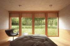 08 The bedroom features a large bed and a comfy chair, the window overlooks the woodland