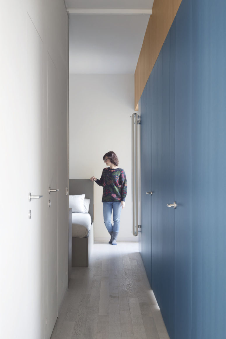 The storage is hidden in the blue and white built-in cabinets in the corridor