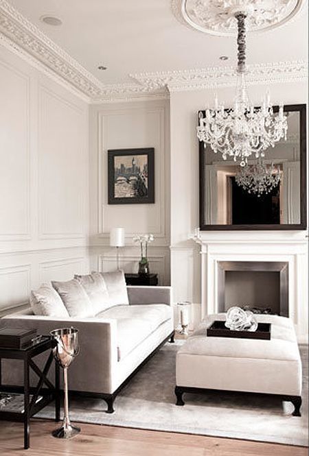 molding on the walls and ceiling and a glam crystal chandelier define this living room