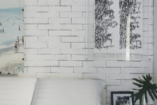 09 On of the two bedrooms with a faux brick wall, bold artworks is filled with natural light