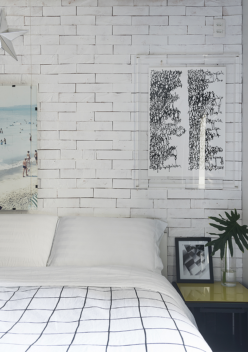 On of the two bedrooms with a faux brick wall, bold artworks is filled with natural light