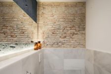 09 The bathroom also features exposed brick like everywhere else, built-in lights and marble