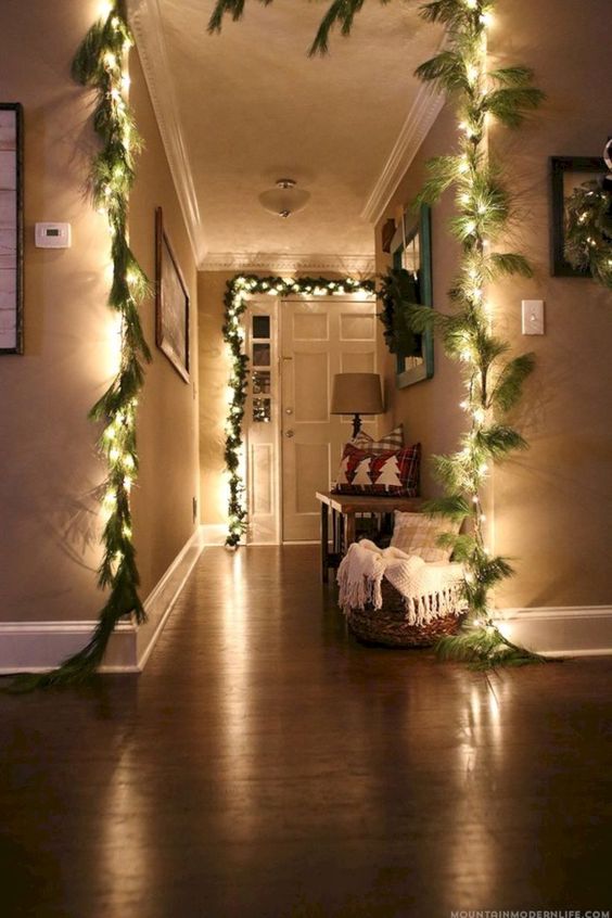 cover the door and archways with string lights to make it shine, here they are combined with faux fir garlands for the holidays