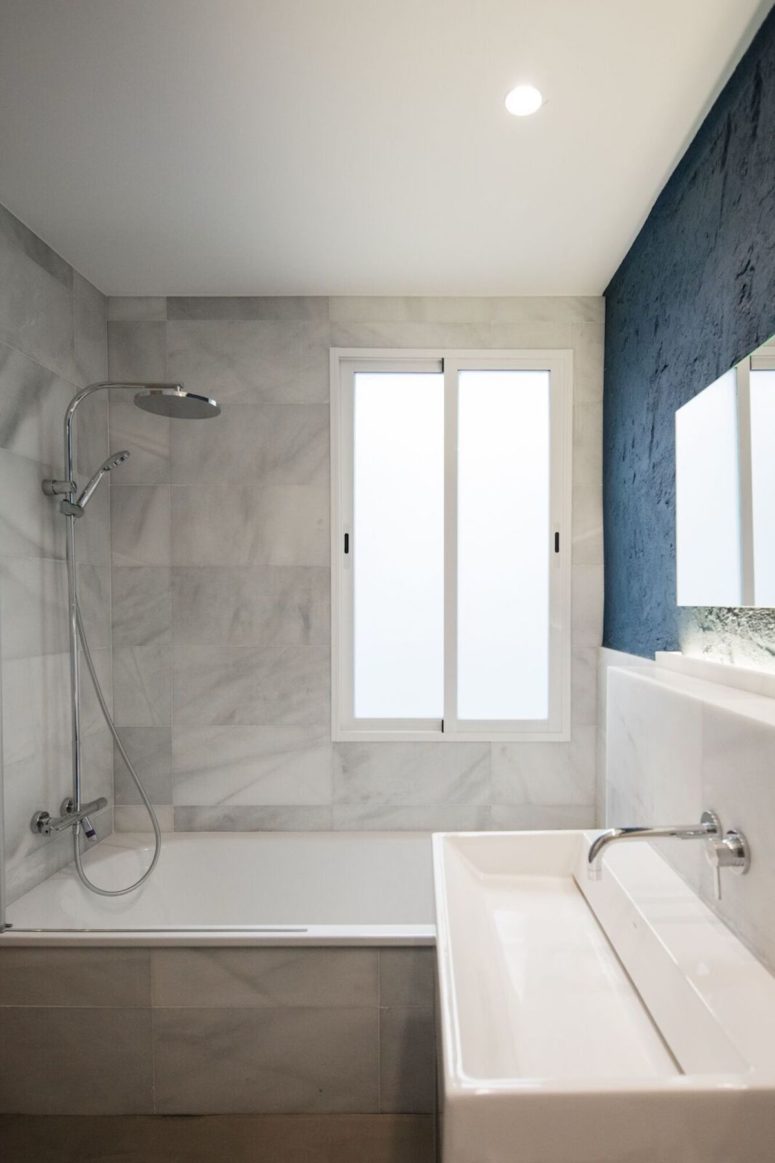 Marble is seen in the other part of the bathroom, too, and there's much light in the space