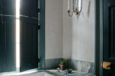 10 The bathroom features dark green shutters and a door and elegant marble surfaces