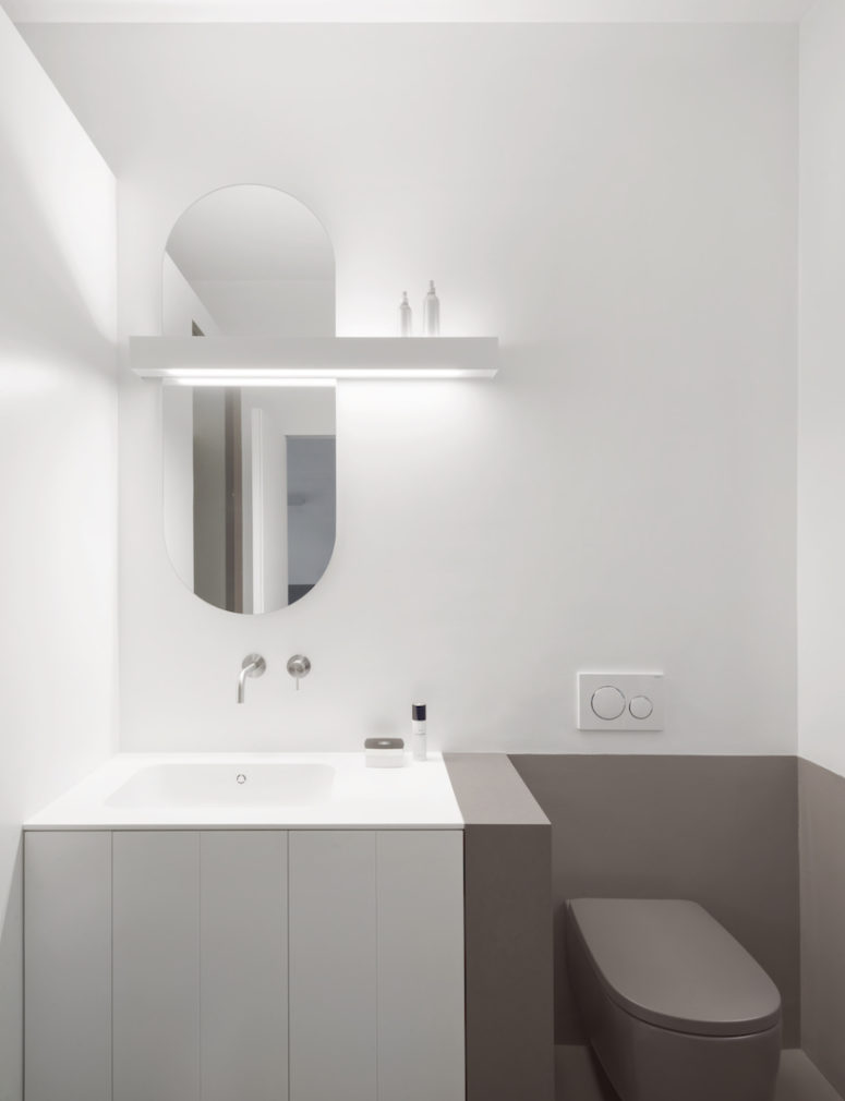 The bathroom is done in grey and white, with minimalist and geometric details